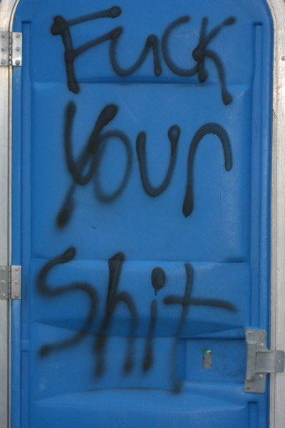Obscene.. yet entertaining. "Fuck your shit" tagged on a porta potty.