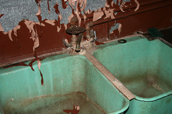 Paint peeling into the dirty sink